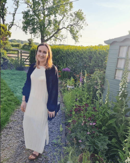 laura stood in a garden in a white dress